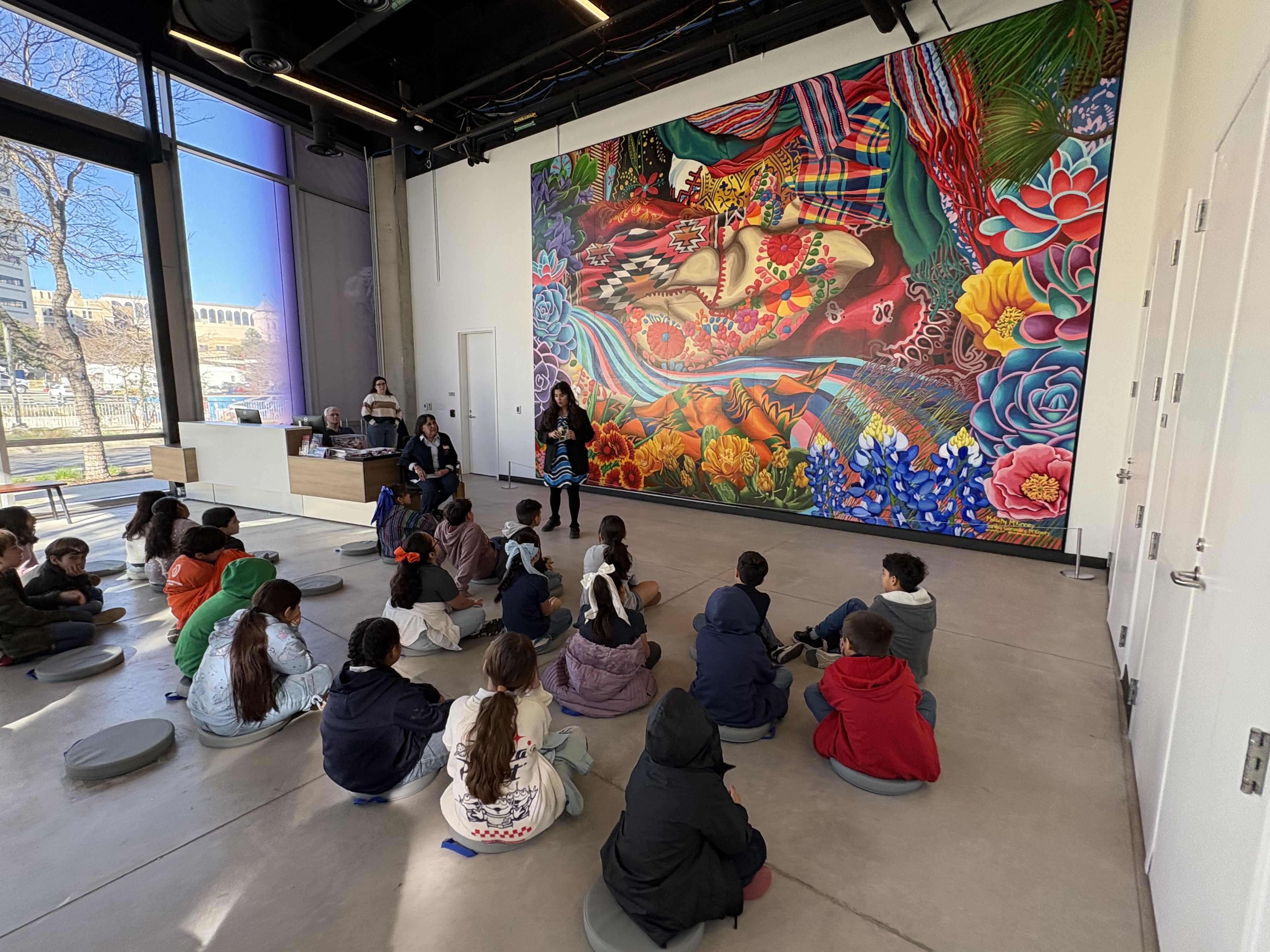 Students in the lobby of the museum, listening to a talk.